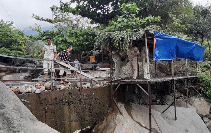 Lực lượng quy tắc đô thị cùng công nhân tháo dỡ các hạng mục xây dựng trái phép. Ảnh: TẤN VIỆT.