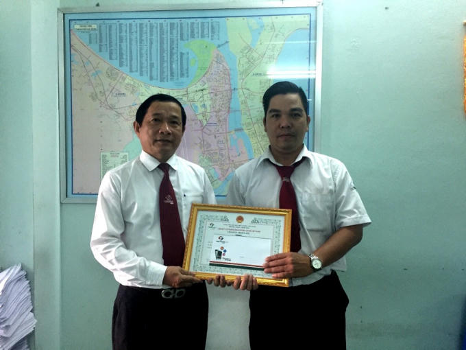 Tài xế Hậu (phải) nhận khen thưởng từ công ty sau khi trả 4.000 USD lại cho khách. 