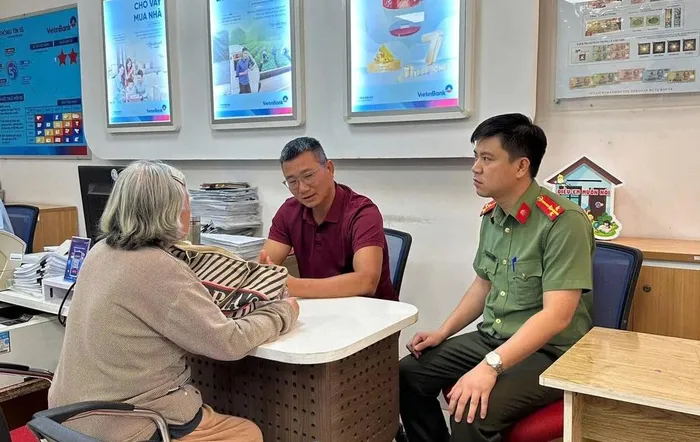 Lực lượng chức năng phối hợp cùng với cán bộ ngân hàng giải thích cho bà H về hành vi lừa đảo, chiếm đoạt tài sản của nhóm tội phạm công nghệ cao. Ảnh: CA Đồng Nai.