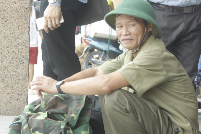 Một số người phải ngồi chờ đợi ngoài cửa do lượng khách mua vé đông.