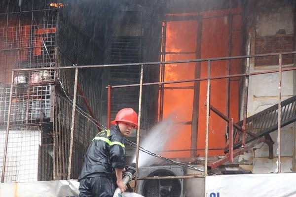 Đám cháy đang được các chiến sĩ Cảnh sát PCCC bơm nước dập tắt.