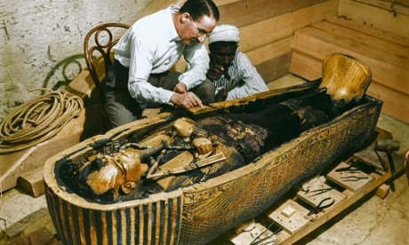 Nhà khảo cổ học Howard Carter và một công nhân Ai Cập kiểm tra quan tài thứ 3 làm bằng vàng được đặt trong 2 chiếc quan tài lớn ở bên ngoài năm 1925.