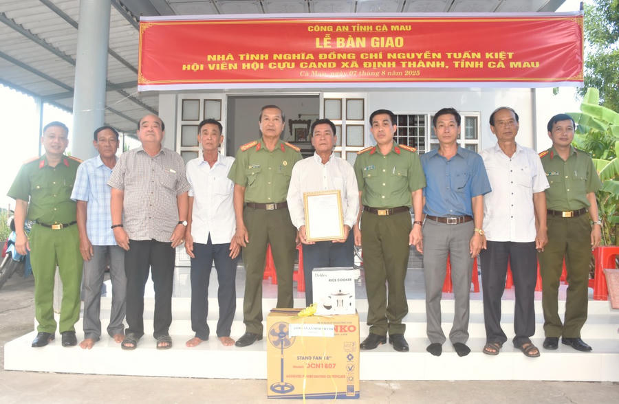 Đại tá Lê Tấn Vinh - Phó Bí thư Đảng ủy, Phó Giám đốc Công an tỉnh Cà Mau (bên phải) bàn giao nhà cho ông Nguyễn Tuấn Kiệt.