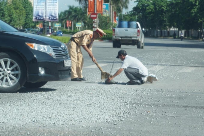 Một người dân đã "góp sức" cùng chiến sĩ CSGT để gom hết số đá trên.
