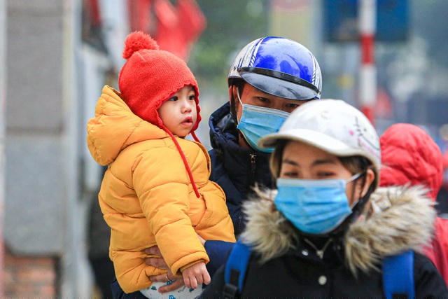 Để chống chọi với cái lạnh nhiều phụ huynh trang bị cho các em nhỏ áo ấm và mũ đội kín.
