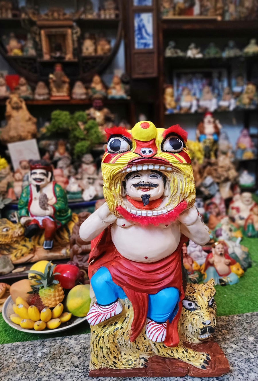 Tượng Ông Địa cưỡi hổ múa lân