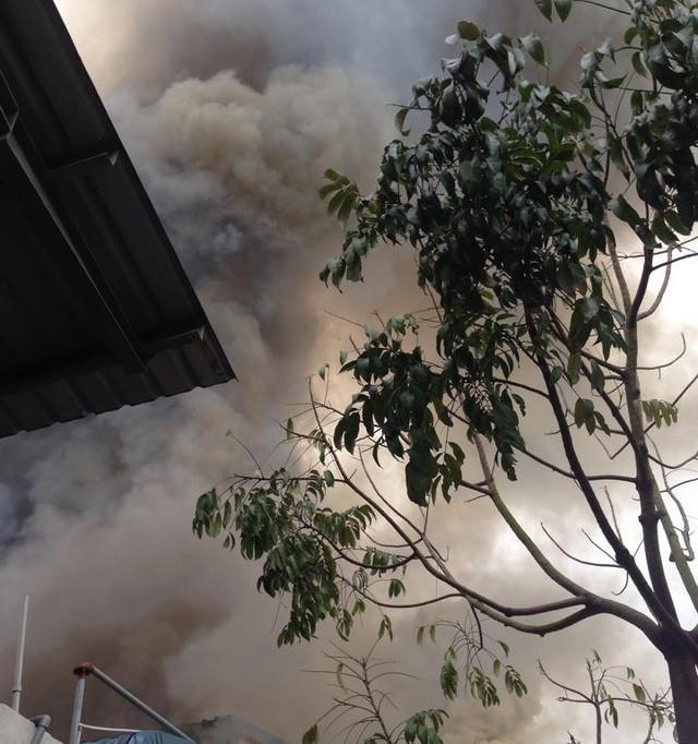 Khói đen bốc cao ngùn ngụt từ trong xưởng. (Ảnh: Người dân cung cấp).