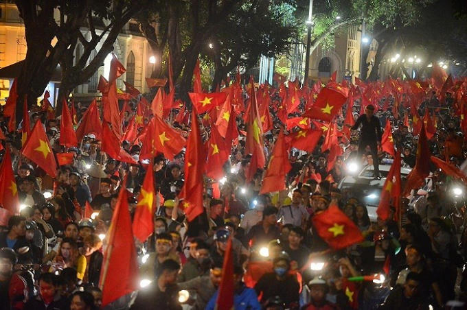 Có những cổ động viên vui mừng, đứng lên cả nóc ô tô để vẫy cờ.