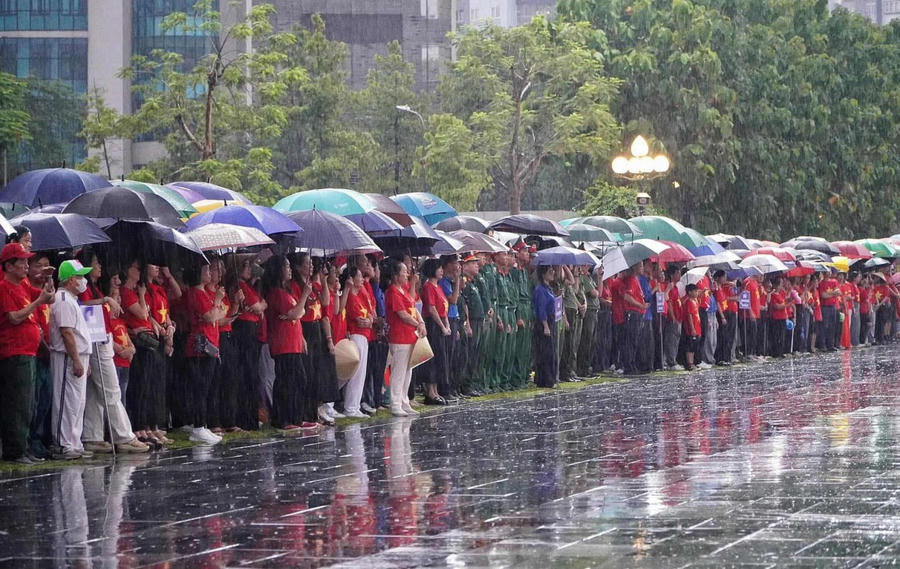 Dù mưa lớn, đông đảo cán bộ, các tầng lớp nhân dân mặc áo đỏ sao vàng tham dự chương trình.