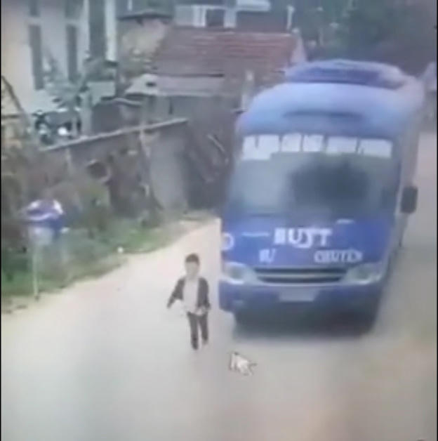 Bé trai thoát chết trước bánh xe buýt. (Ảnh cắt từ clip).