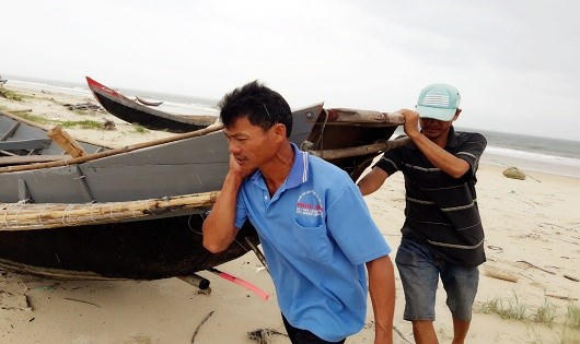 Người dân khẩn trương đưa thuyền lên bờ.