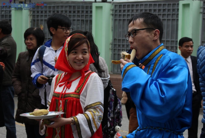 Những người đàn ông nhanh chóng ăn chuối tiêu để "cởi" chiếc áo màu xanh (dành cho phụ nữ) để nhận những phần quà đặc biệt. (Ảnh: Đức Biên)