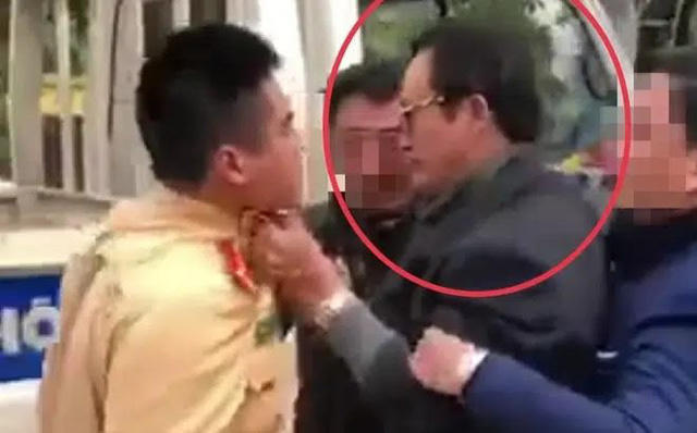 Hình ảnh ông Lại Quốc Đạt túm cổ áo CSGT khi bị yêu cầu kiểm tra nồng độ cồn. Ảnh cắt từ clip.