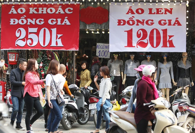 Tấm biển giảm giá phủ gần một nửa diện tích mặt tiền của một cửa hàng trên phố Bà Triệu.