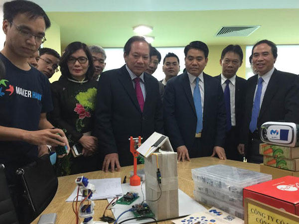 Bộ trưởng Bộ TT&amp;TT Trương Minh Tuấn và Chủ tịch UBND TP Hà Nội Nguyễn Đức Chung thăm quan các sản phẩm ứng dụng CNTT. Ảnh: KTĐT