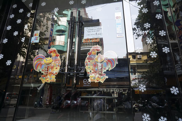 Rất nhiều cửa hàng buôn bán mặt phố đều dán hình ảnh gà để chào đón năm mới Đinh Dậu.