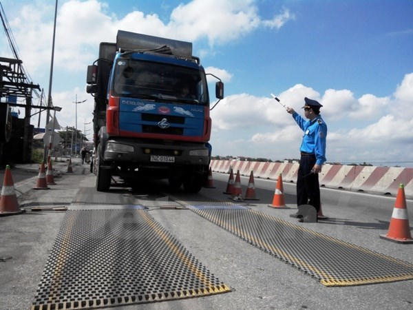 Lực lượng chức năng tiến hành kiểm tra tải trọng xe. (Ảnh: Việt Hùng/Vietnam+)