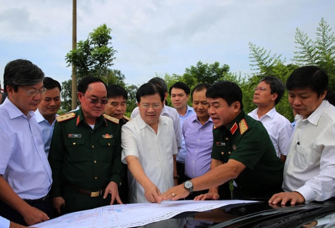 Phó Thủ tướng Trịnh Đình Dũng (giữa) cùng Trung tướng Võ Văn Tuấn (thứ 2 từ phải sang) kiểm tra thực địa khu vực dự kiến mở rộng sân bay Tân Sơn Nhất.