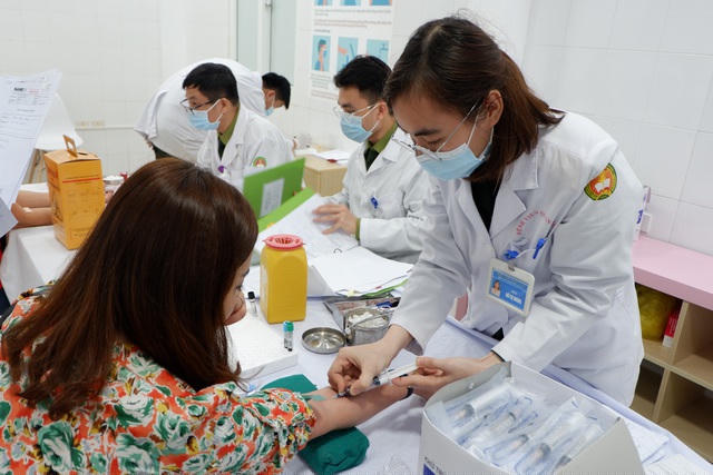 Một tình nguyện viên được lấy máu kiểm tra sức khỏe trước khi tiêm vắc xin.