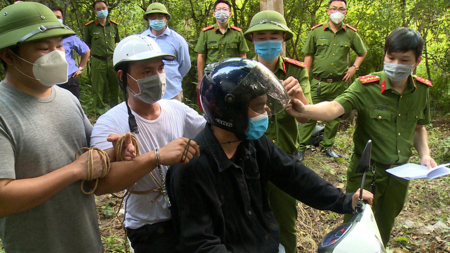 Đối tượng Tuấn (áo trắng) thực hiện lại hành vi siết cổ nạn nhân. Ảnh: Công an cung cấp.