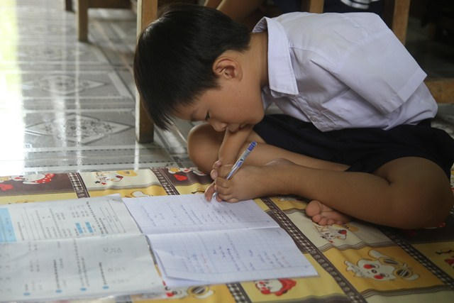 Em Tài đang chăm chỉ viết bài.