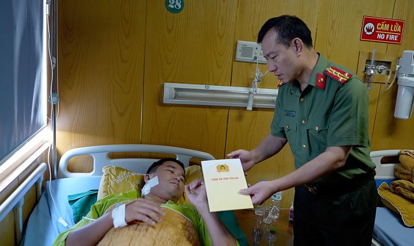 Đại tá Đinh Xuân Thiệp - Phó Giám đốc Công an tỉnh Yên Bái thăm hỏi Thiếu tá Lương Văn Chiến. (Ảnh: Báo yên Bái).