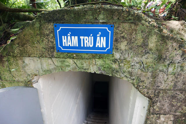 Hầm trú ẩn được bố trí cách "Nhà sàn" khoảng 10m, nguỵ trang khuất dưới những tán cây cổ thụ.