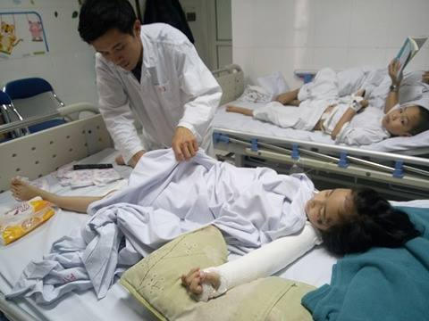 Anh Tân chăm sóc cho đứa con gái nhỏ đang nằm trên giường bệnh. (Ảnh: Thành Lâm)