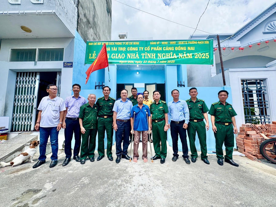 Các đại biểu và gia đình ông Trần Văn Hùng vui mừng chụp hình bên ngôi nhà mới