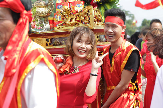 Các cô gái tươi cười khiêng kiệu.