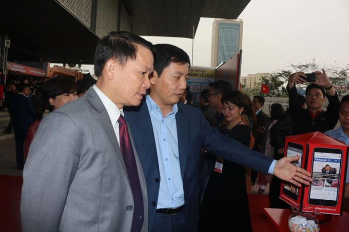 Phó Tổng biên tập Báo Pháp luật Việt Nam Trần Đức Vinh giới thiệu các ấn phẩm điện tử của Báo Pháp luật Việt Nam với ông Nguyễn Đức Lợi, Ủy viên Trung ương Đảng, Tổng Giám đốc Thông tấn xã Việt Nam.