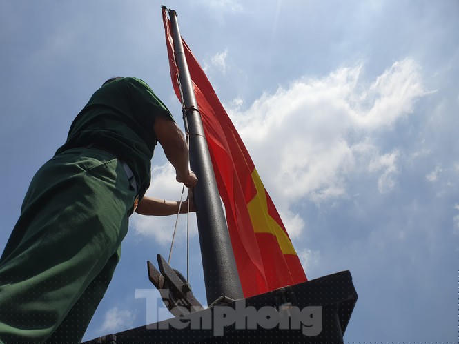 Khi hạ cờ người ở trên túm phần đuôi, níu xuống để hai người phía dưới giữ lại, không để cờ tung lên theo gió,động tác thực hiện phải nhanh gọn, dứt khoát (trong ảnh là Thượng úy Lưu Ngọc Huân, người có 4 năm nhận nhiệm vụ trong tổ đảm bảo cờ)