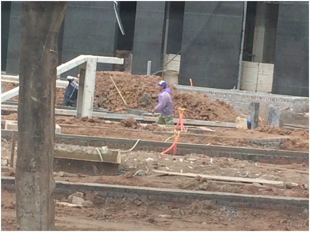 Công nhân tại một công trường mặc áo mưa chống rét.