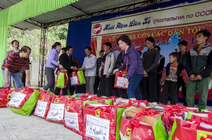 Các đại diện nhóm Hoài niệm Liên Xô tiếp tục trao phần quà Tết đến đại diện các hộ nghèo. (Ảnh: Phạm Thanh Hà)