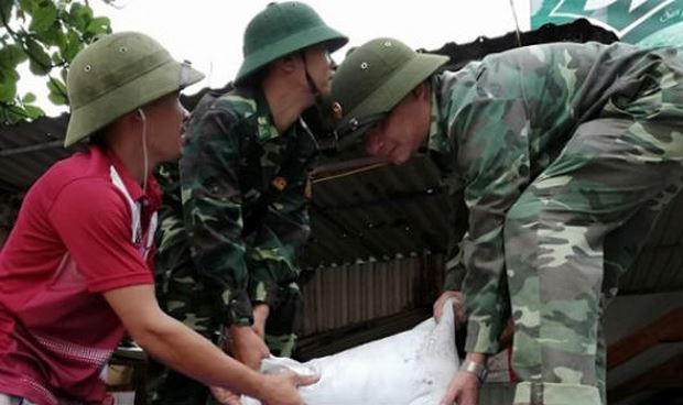 Cán bộ Đồn Biên phòng cảng Cửa Lò - Bến Thủy giúp dân chằng chống nhà cửa.