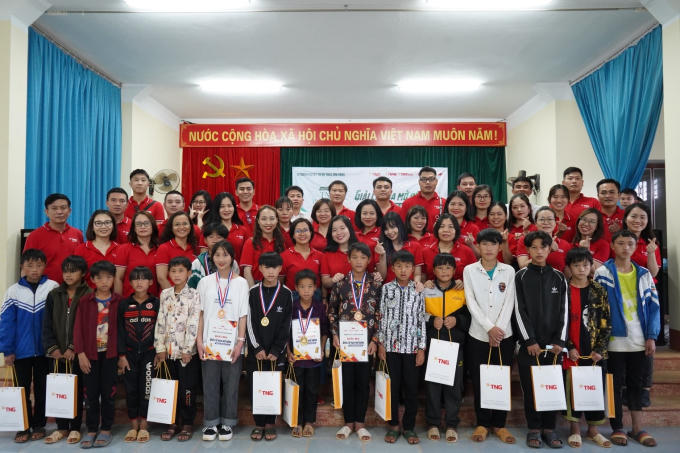 Cán bộ nhân viên công ty TNS chụp trao quà cho các em học sinh.