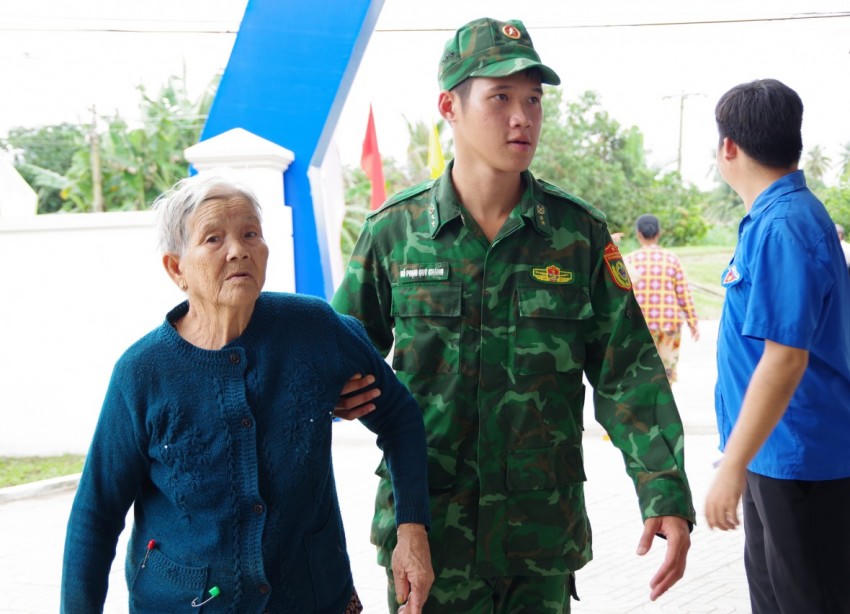 Cán bộ, chiến sĩ Bộ đội Biên phòng hỗ trợ người dân đến khám bệnh