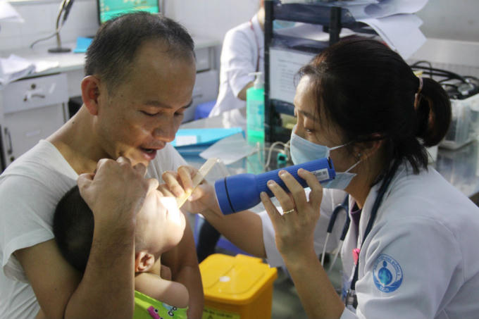 Các bậc phụ huynh khi đưa con tới khám. Dù các bé tỏ ra khá mệt mỏi, khóc thét, nhưng không ai yêu cầu phải khám trước cho con mình. Họ chờ tới lượt.