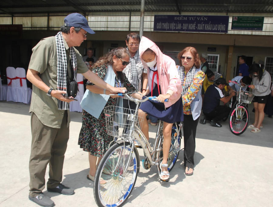 Nhóm cô, chú học sinh miền Nam tại TP. Hồ Chí Minh, thăm hỏi và hướng dẫn các em điều chỉnh yên xe cho phù hợp với tư thế đạp xe.