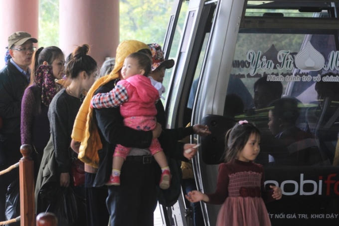 Du khách xếp hàng để được hướng dẫn vào cáp treo.