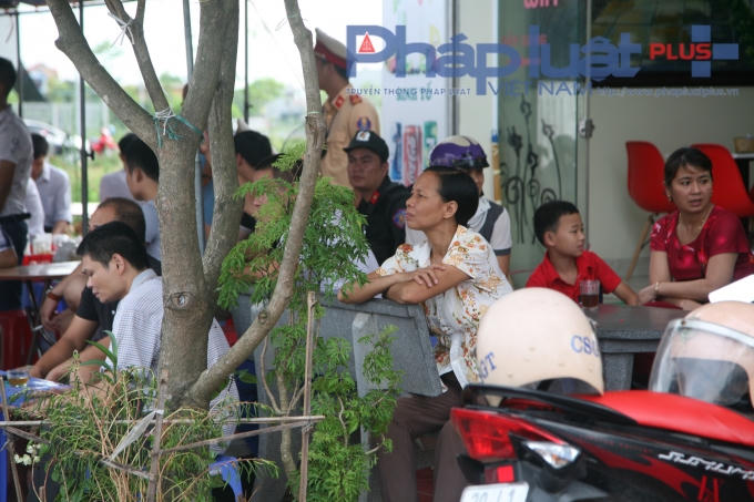 Hình ảnh một người mẹ trong tâm trạng lo lắng đang trông ngóng về phía cổng trường.