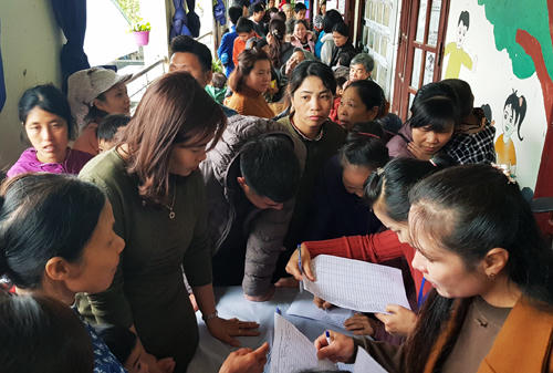 Phụ huynh xếp hàng đăng ký cho con xét nghiệm tại Trường Mầm non Thanh Khương sáng 18/3.