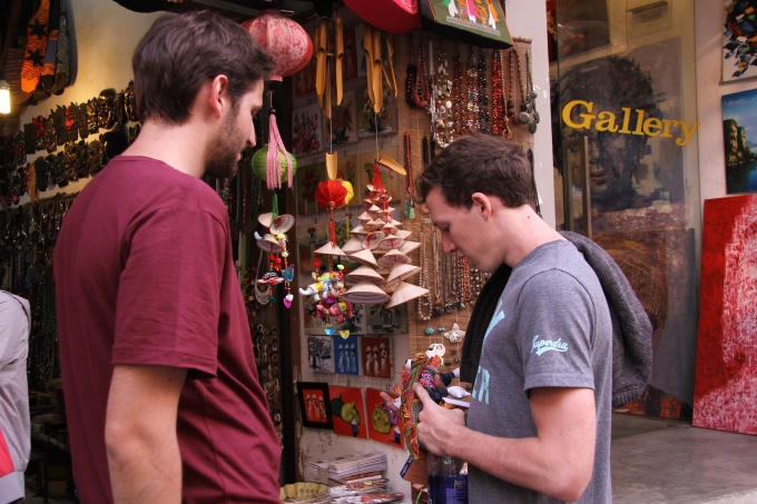 Một du khách người Pháp đang chăm chú xem các sản phẩm len tại phố Đinh Liệt