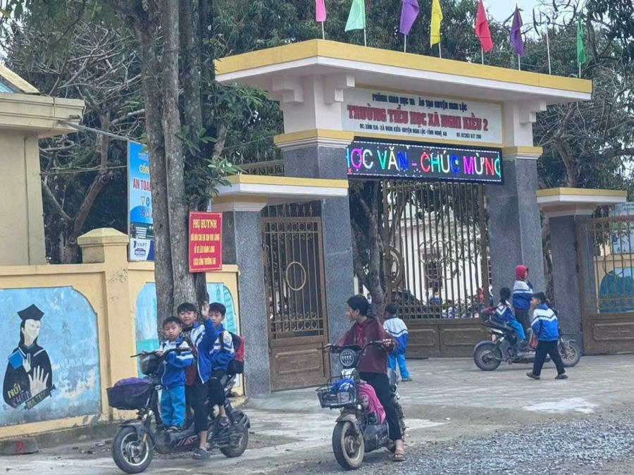 Học sinh Tiểu học đi xe máy điện tới trường.