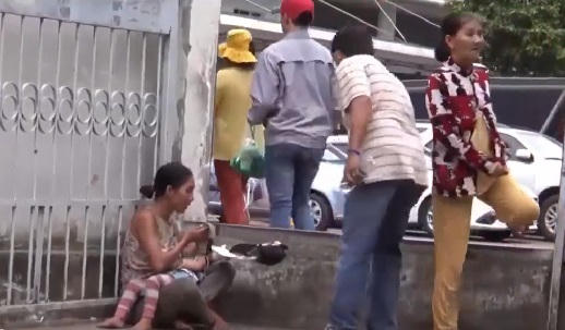 Lợi dụng trẻ em để xin tiền. (Ảnh: Cắt từ clip)