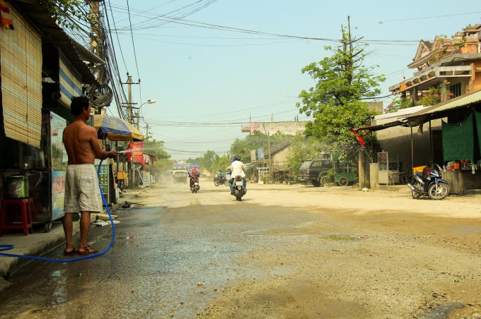 Những ngày nắng thì bụi bay mù mịt, người dân phải xịt nước trước nhà để giảm bớt bụi.