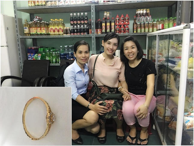 Du khách Bích Châu (giữa) nhận lại chiếc lắc vàng từ nhân viên BQL và vợ anh Hùng (áo đen). Ảnh: NVCC.