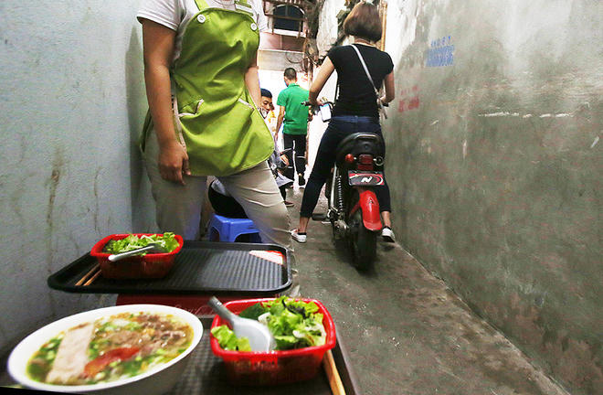 Hàng ăn sáng trong một ngõ nhỏ trên đường Hàng Bông, con ngõ này có chiều rộng khoảng 80 cm, chỉ đủ kê một hàng ghế và dành phần còn lại cho các phương tiện giao thông.