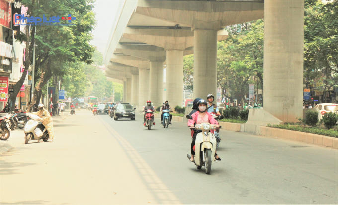 Trên tuyến đường Xuân Thủy (Cầu Giấy), người đi xe máy đi nép vào khu vực bóng mát để tránh cái nóng oi ả.