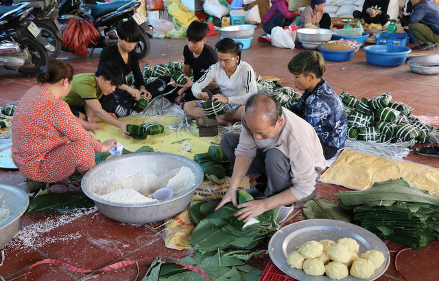 Làng Tranh Khúc quanh năm làm bánh chưng cung cấp cho cả Hà Nội. Vào những ngày giáp Tết, mỗi gia đình làm bánh chưng ở Thanh Khúc cần từ 10 - 25 người phục vụ gói bánh và làm các công đoạn chuẩn bị. Trong ảnh là cảnh gia đình ông Nguyễn Văn Điệp đang tất bật hoàn thiện những đơn hàng có số lượng lớn. Ông Điệp cho biết vào những cao điểm gia đình ông xuất cả nghìn bánh đi khắp mọi nơi.